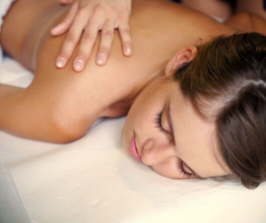 Eine Frau erhält eine wohltuende Massage im Wellnesshotel Gut Ising am Chiemsee.